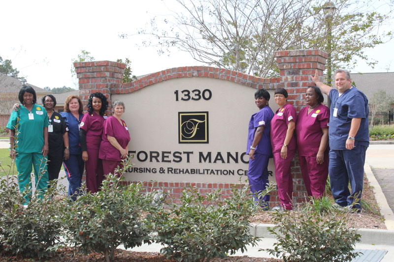 Staff standing in front of sign